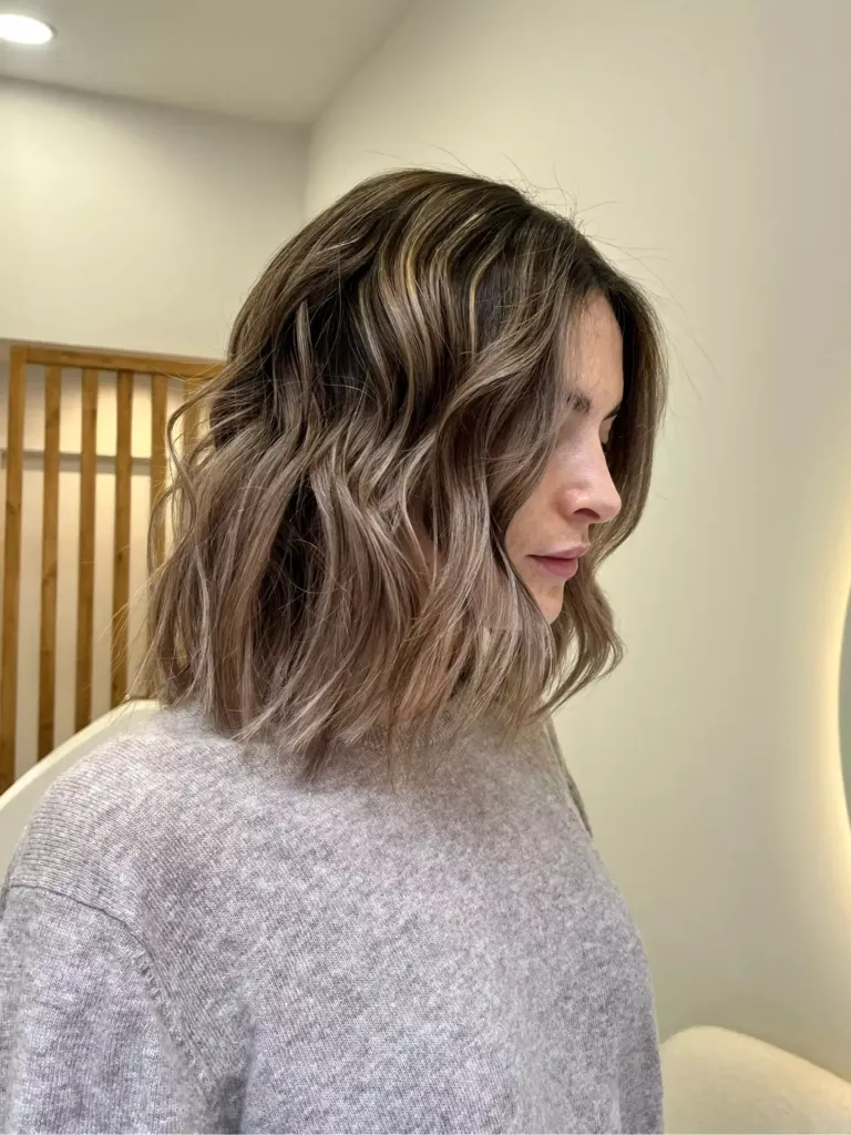 Mujer con corte media melena y mechas rubias