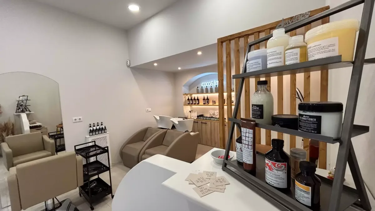 Expositor con productos de belleza de la marca Davines, al fondo la zona de lavado y la de corte y peinado