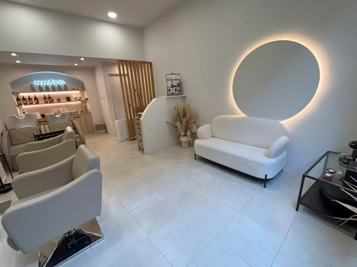 Sofá bajo un espejo en el salón de belleza
